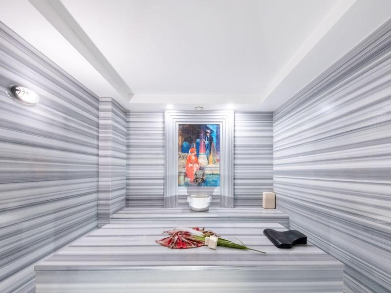 Moderne kamer met gestreepte muren, centrale zitplaats en een schilderij aan de muur.