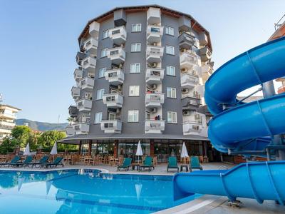 Rundes mehrstöckiges Hotel mit Balkonen, blauem Wasserrutschen-Ausschnitt und großem Pool.