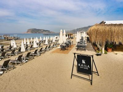 Plage avec chaises longues, parasols et restaurant au toit de chaume au bord de la mer