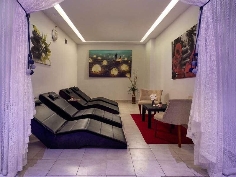 Trois chaises longues noires dans une pièce avec rideaux, œuvres d'art et coin salon confortable.