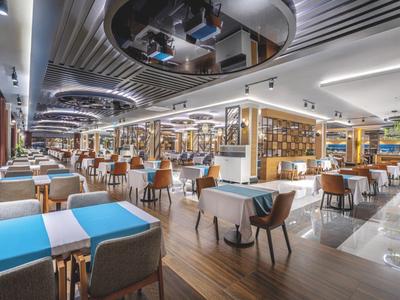 Ristorante moderno e luminoso con tavoli e sedie elegantemente disposti all'interno.