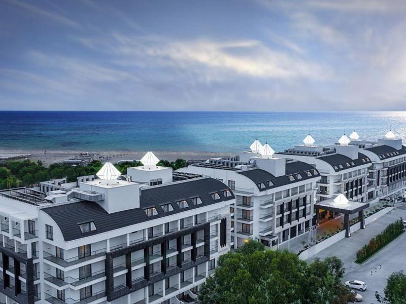 Widok z lotu ptaka na nowoczesny hotel blisko morza pod częściowo pochmurnym niebem.