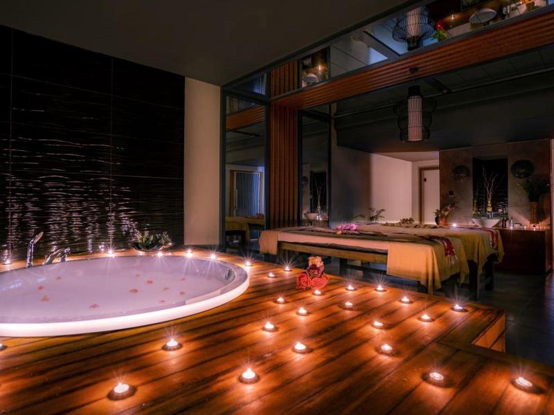 Jacuzzi otoczona świecami w przytulnym, klimatycznym spa.