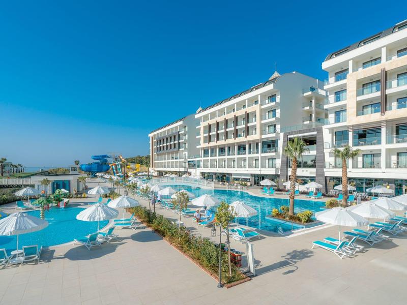 Nowoczesny kompleks hotelowy z kilkoma basenami, parasolami i leżakami pod czystym niebem