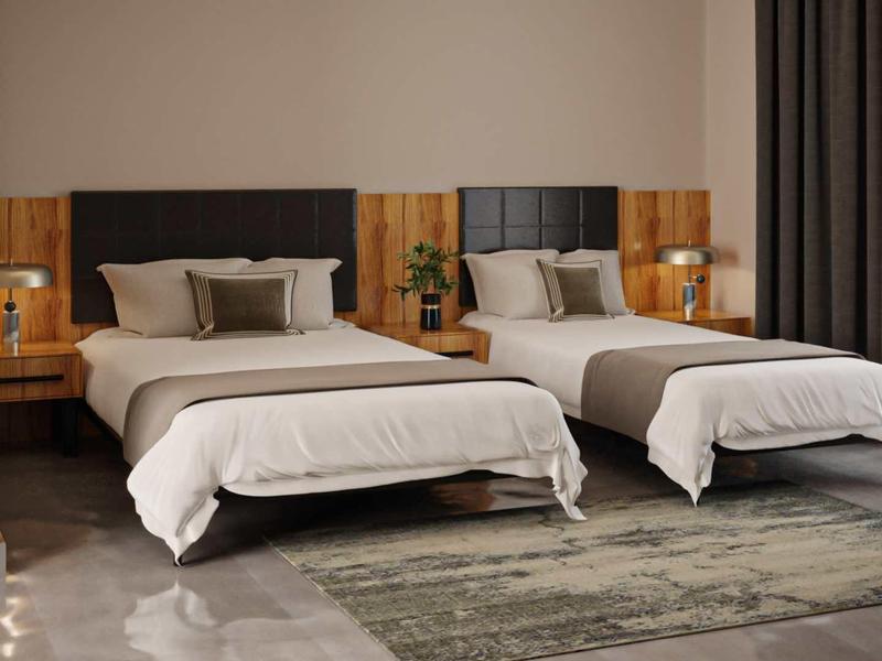 Habitación de hotel moderna con dos camas individuales, pared de madera y grandes cortinas junto a la ventana.