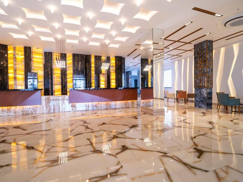 Amplio vestíbulo de hotel con suelo de mármol brillante y diseño moderno y luminoso.