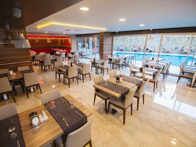 Leeres modernes Restaurant mit Holztischen, bequemen Stühlen und großem Fenster zum Außenbereich.
