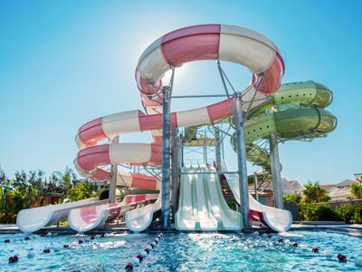 Grande scivolo acquatico colorato in una piscina all'aperto sotto un cielo azzurro.