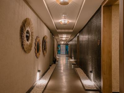 Corridoio moderno dell'hotel con luce calda, specchi decorativi e vista esterna