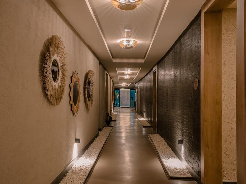 Corridoio moderno dell'hotel con luce calda, specchi decorativi e vista esterna