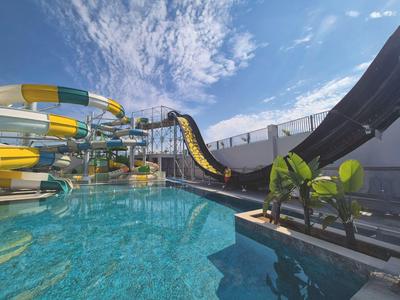Water park with water slides next to a pool under a clear blue sky