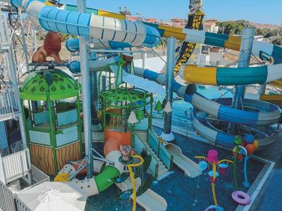 Parque acuático colorido con grandes toboganes y estructuras de juegos de agua al aire libre.