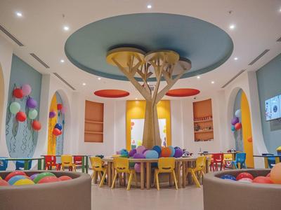 Colorfully furnished round dining room with central tree decor and balloons on the walls.