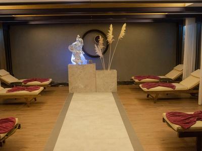Nowoczesna strefa wellness z wygodnymi leżakami, rzeźbą i dekoracyjnymi roślinami.