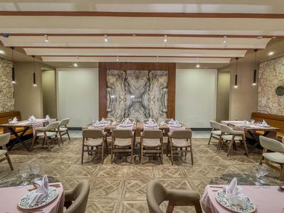 Elegancka restauracja z rustykalnym kamiennym wystrojem ścian i przytulnymi drewnianymi meblami w hotelu.