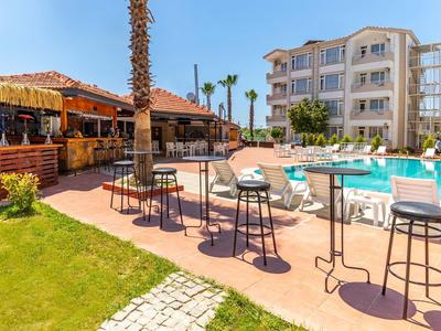 Moderne zwembadgebied met bar, hoge tafels en een meerlaagse hotelgebouw op de achtergrond.