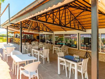 Gezellig buitenterras met tafels en stoelen onder een groot zonnescherm.