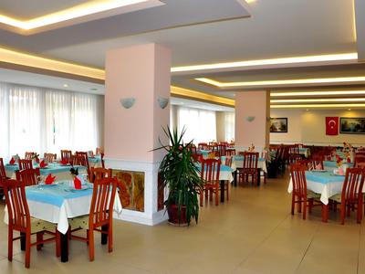 Restaurant d'hôtel lumineux et moderne avec des chaises en bois et nappes bleues.