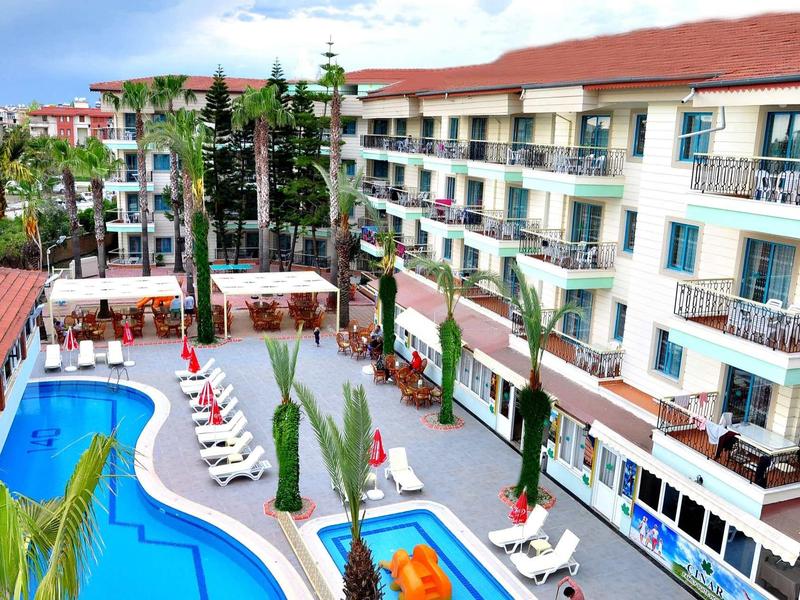 Hotel met zwembaden, zonneterrassen en palmbomen onder blauwe lucht