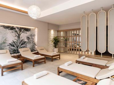 Elegantní wellness prostor s pohodlnými lehátky, jemným osvětlením a přírodní výzdobou.