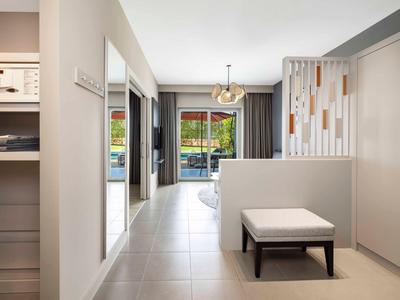 Moderní chodba s lavicí, skříní a výhledem do obývacího pokoje s terasou