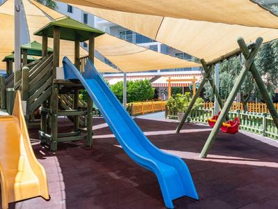 Dětské hřiště s klouzačkami a houpačkami pod slunečními plachtami v hotelu