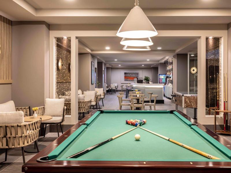 Interiér se zeleným kulečníkovým stolem a stylovým posezením v hotelu