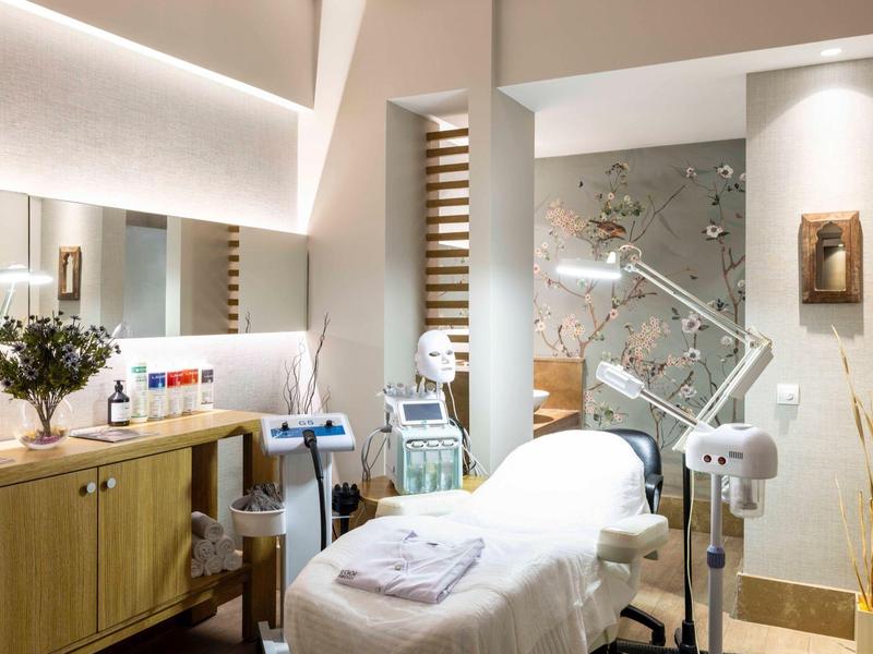 Světla, moderní léčebna s lehátkem, dřevěnou skříní a dekorativními prvky.