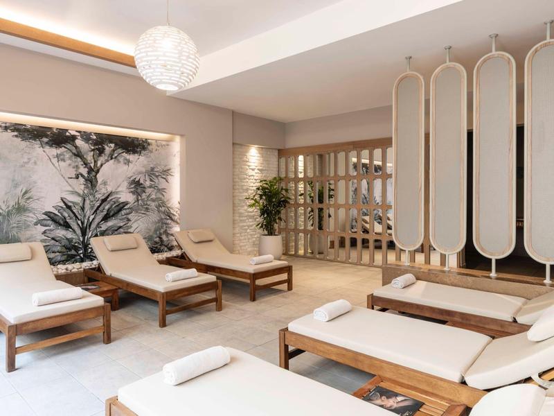 Elegantní wellness prostor s pohodlnými lehátky, jemným osvětlením a přírodní výzdobou.