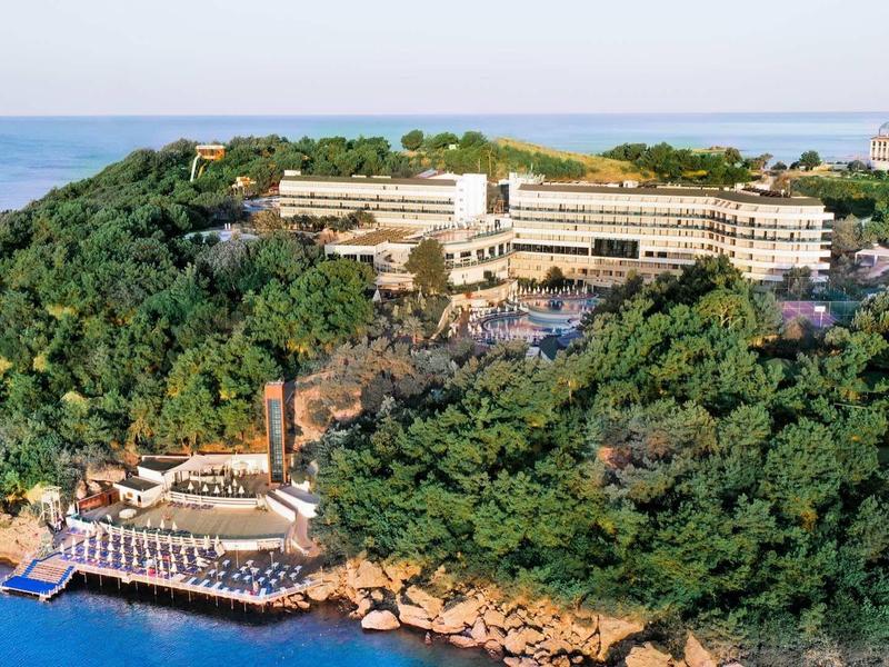 Kompleks hotelowy na zalesionym klifie z plażą nad morzem