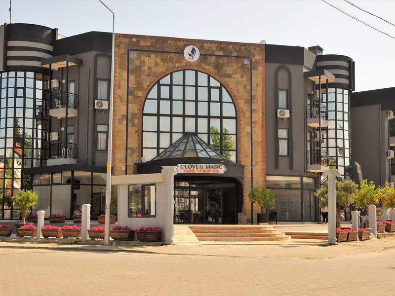 Nowoczesny budynek hotelu z dużymi oknami i dwoma okrągłymi wieżami po bokach.