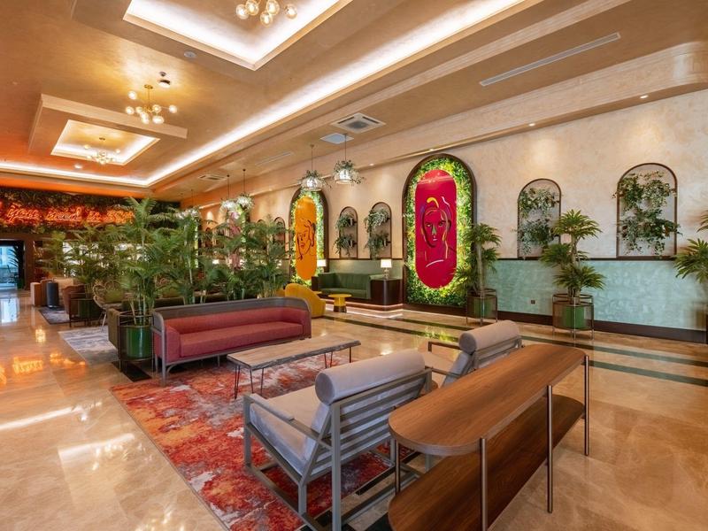 Elegantní hotelová lobby s moderním nábytkem, rostlinami a teplým osvětlením.
