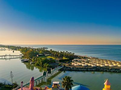 Luchtfoto van een kustlandschap met waterwegen, bruggen en gebouwen bij zonsondergang.