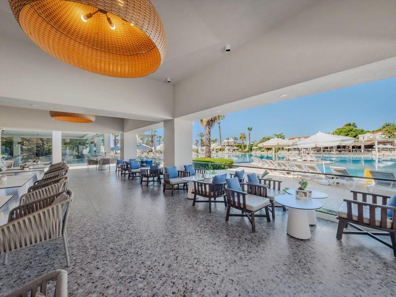 Moderna terras met zitplaatsen en uitzicht op een hotelzwembad