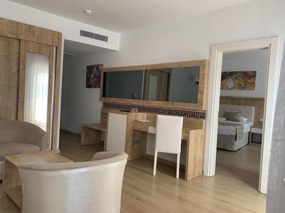 Camera d'hotel moderna con mobili in legno e due spazi collegati.