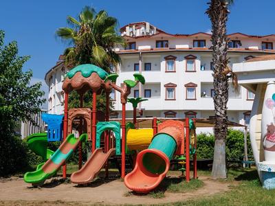 Scivoli colorati del parco giochi davanti a un hotel sotto un cielo azzurro