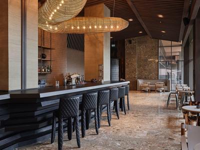 Area bar dell'hotel moderna con sgabelli neri e illuminazione elegante