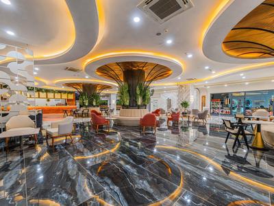 Elegante hotel lobby met marmeren vloer, moderne verlichting en comfortabele zithoeken.