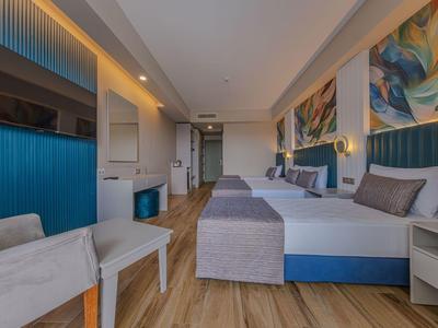 Moderne hotelkamer met twee bedden, kleurrijke wanddecoratie en houten vloer.