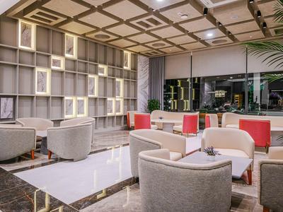 Moderne hotel-lounge met comfortabele fauteuils en grote boekenkast.