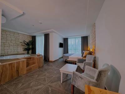 Moderne woonkamer met zitplaatsen, tafel en raamzicht in een hotelkamer.