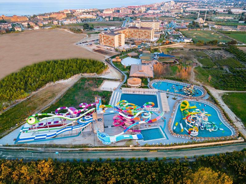 Luchtfoto van een groot waterpark met glijbanen en zwembaden in een stedelijk gebied.