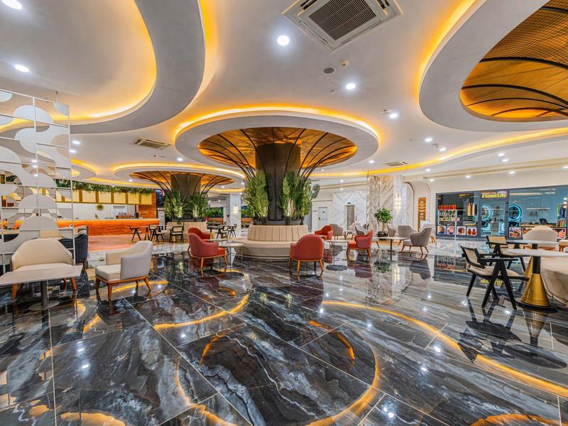 Elegante hotel lobby met marmeren vloer, moderne verlichting en comfortabele zithoeken.