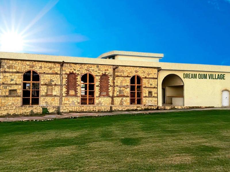 Hotel met traditionele architectuur en groot gazon onder heldere hemel