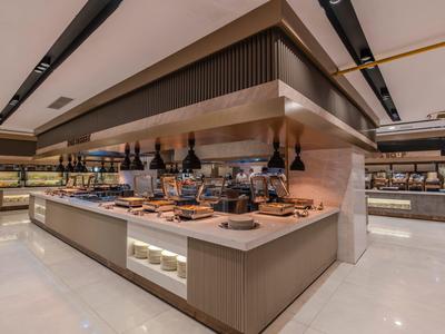 Buffetbereich mit einer großen Auswahl an Speisen und Weinen in modernem Hotelrestaurant.