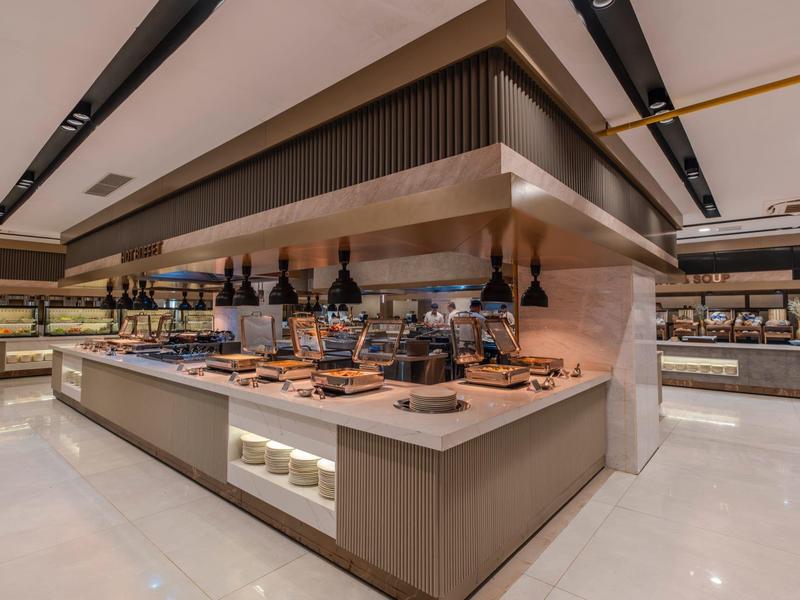 Buffetbereich mit einer großen Auswahl an Speisen und Weinen in modernem Hotelrestaurant.