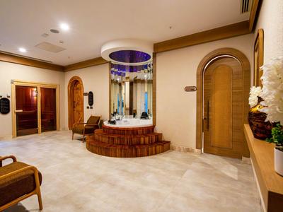 Soukromá vířivka v luxusním hotelovém pokoji s teplým osvětlením a dřevěným nábytkem