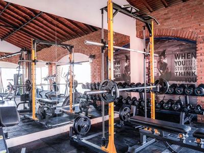 Salle de sport moderne avec poids, miroirs et plafonds en bois dans un hôtel