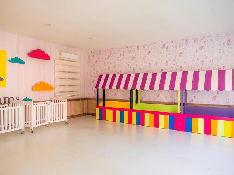 Espace de jeux pour enfants coloré avec lits, décorations murales et pièce lumineuse.