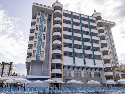 Nowoczesny hotel wielopiętrowy z balkonami i leżakami przy basenie.